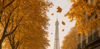 Turistas paseando por París en otoño con hojas naranjas cayendo de los árboles y la Torre Eiffel al fondo